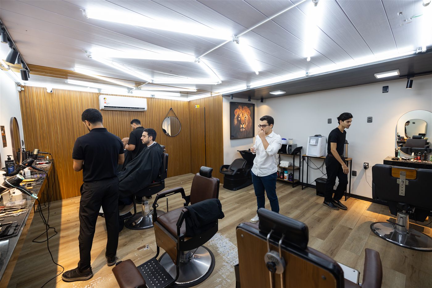 Equipe da barbearia reunida no salão, alinhando a rotina do dia