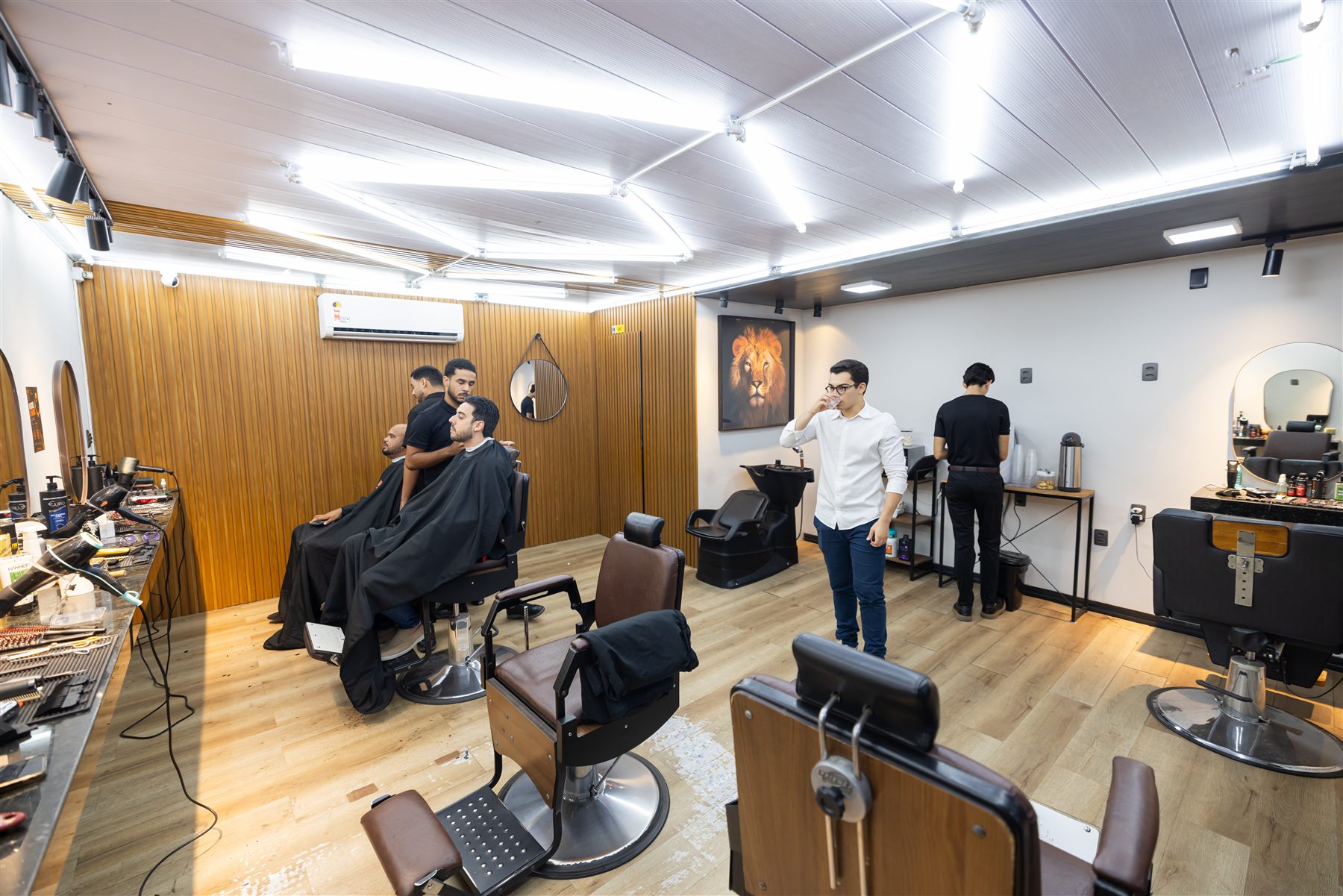 Interior de barbearia parceira, cadeiras e bancada de trabalho